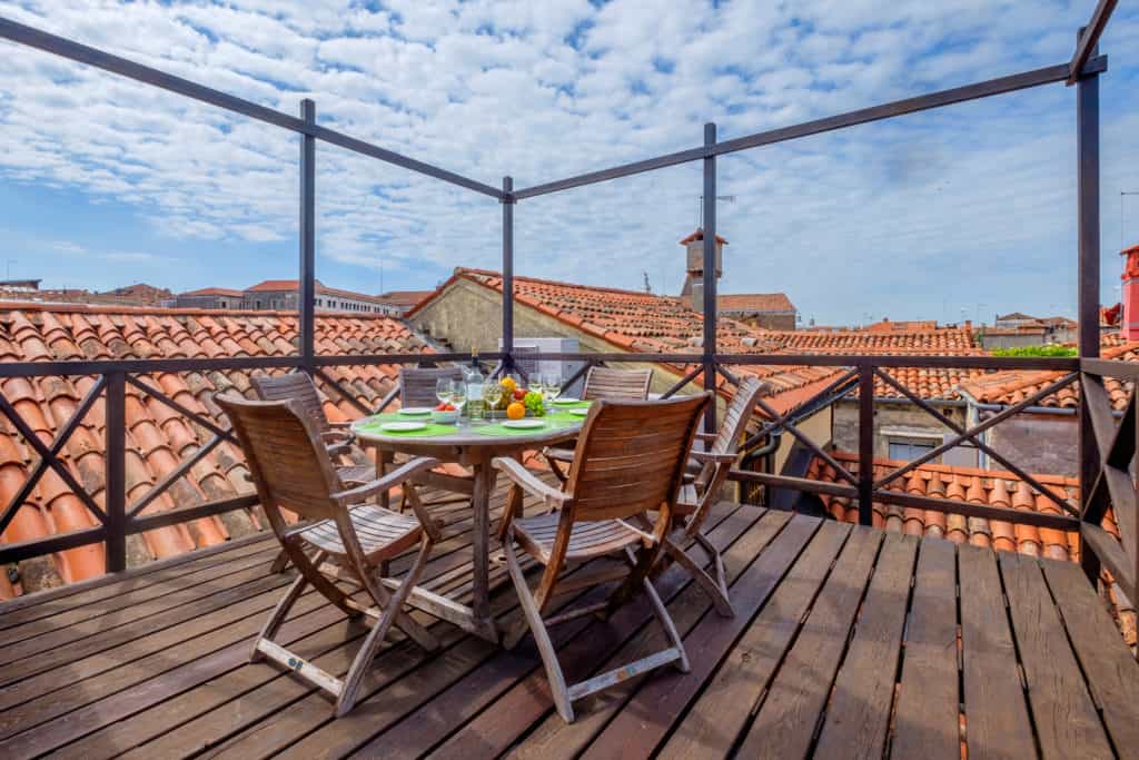 Wooden terrace with small dining table and view on the Venetian roofs - Ca' Affresco 1 Apartment Wooden terrace with small dining table and view on the Venetian roofs - Ca' Affresco 1 Apartment