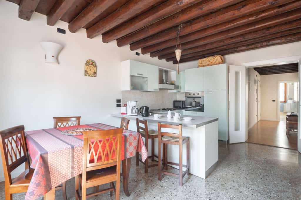 Entrance of the kitchen with dining table - Ca' Coriandolo Apartment Entrance of the kitchen with dining table - Ca' Coriandolo Apartment