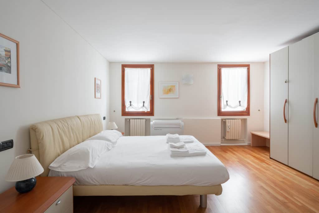 Left view of the large master bedroom with wardrobe - Ca' Coriandolo Apartment Left view of the large master bedroom with wardrobe - Ca' Coriandolo Apartment