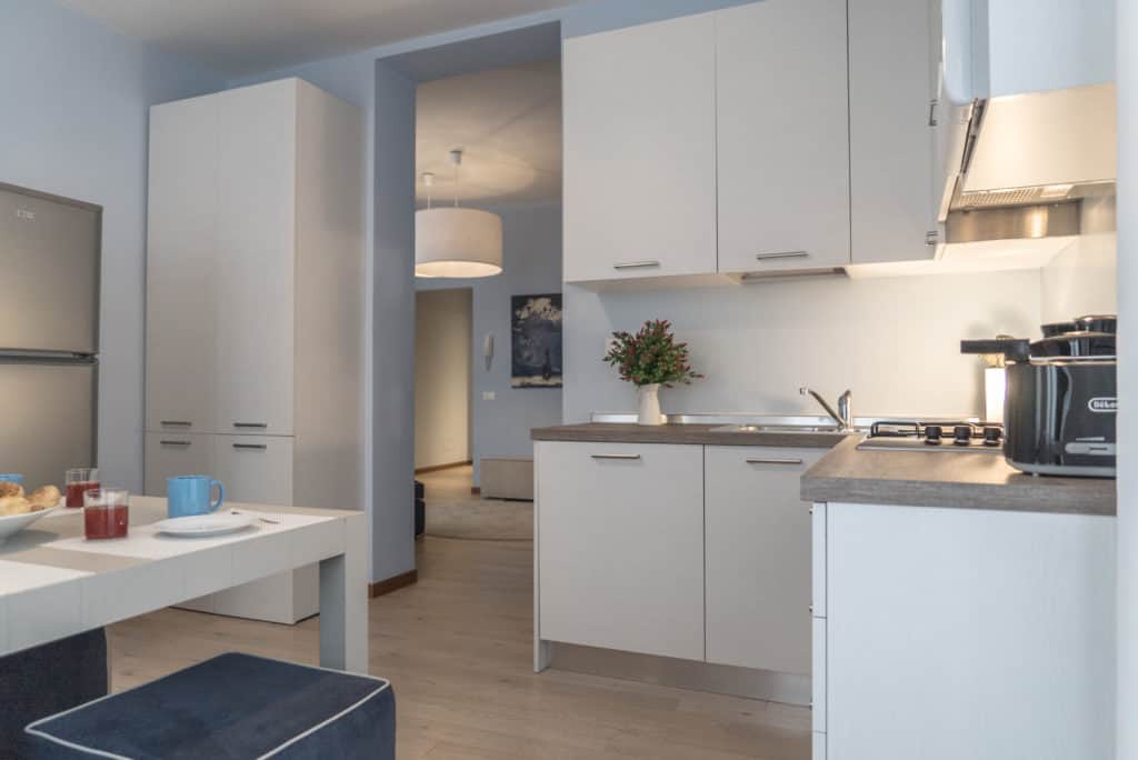 Entrance of the kitchen with dining table and modern furnishing Entrance of the kitchen with dining table and modern furnishing - Ca' del Capitano Apartment