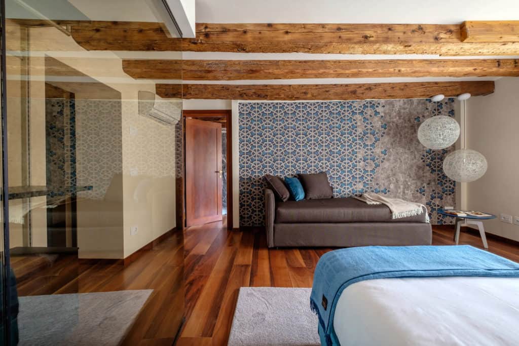 Luminous bedroom with sofa and exposed beams - Ca' Garzoni Moro - Lido Apartment Luminous bedroom with sofa and exposed beams - Ca' Garzoni Moro - Lido Apartment