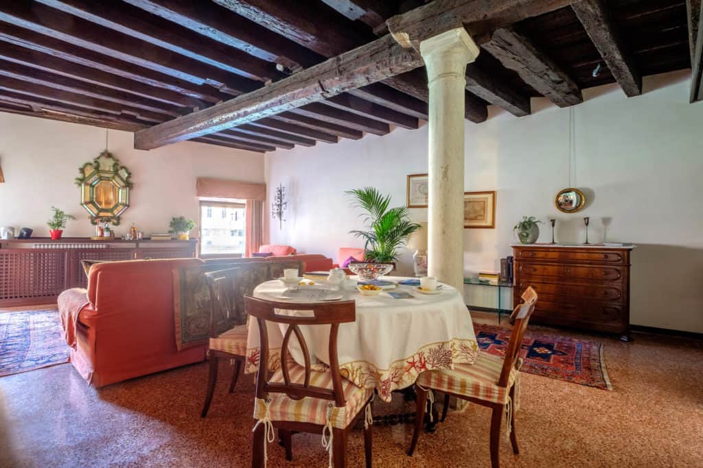 RIght view of the large and luminous living room with dining table, colums and exposed beams - Ca' Mocenigo Apartment RIght view of the large and luminous living room with dining table, colums and exposed beams - Ca' Mocenigo Apartment