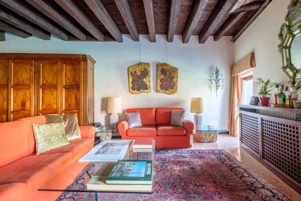 Left view of the large and luminous living room with vintage furnishing, colums and exposed beams - Ca' Mocenigo Apartment Left view of the large and luminous living room with vintage furnishing, colums and exposed beams - Ca' Mocenigo Apartment