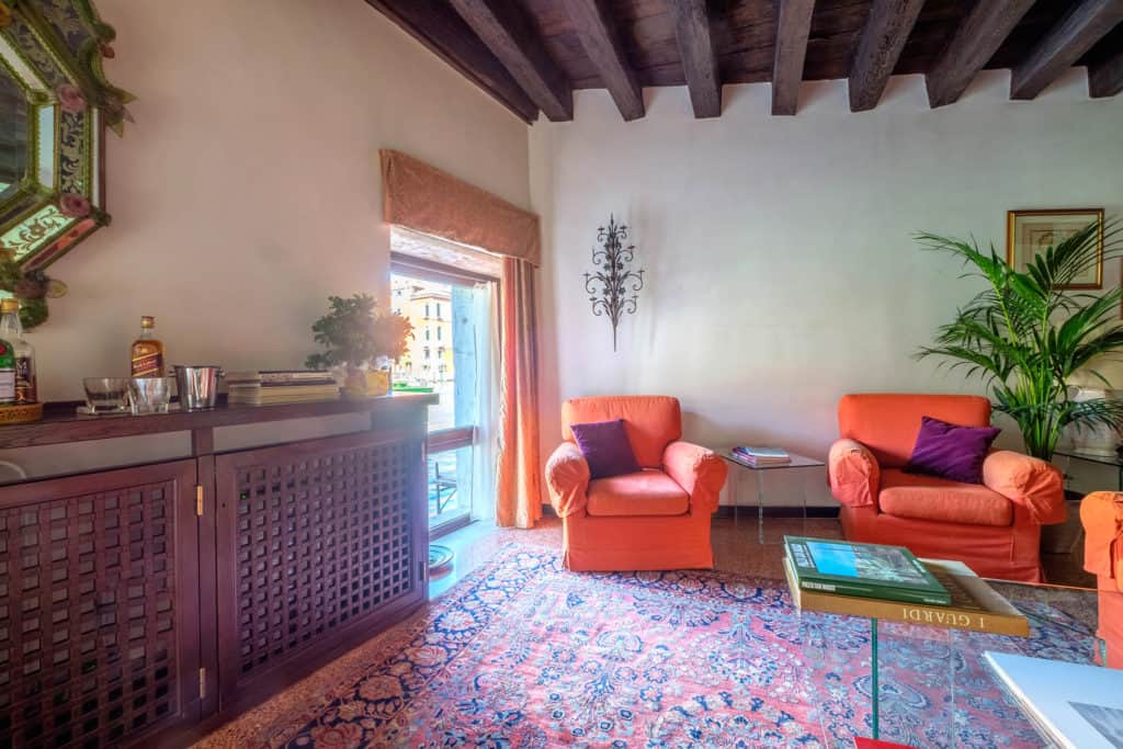 Living room with armchairs, large window, vintage furnishing and exposed beams - Ca' Mocenigo Apartment Living room with armchairs, large window, vintage furnishing and exposed beams - Ca' Mocenigo Apartment