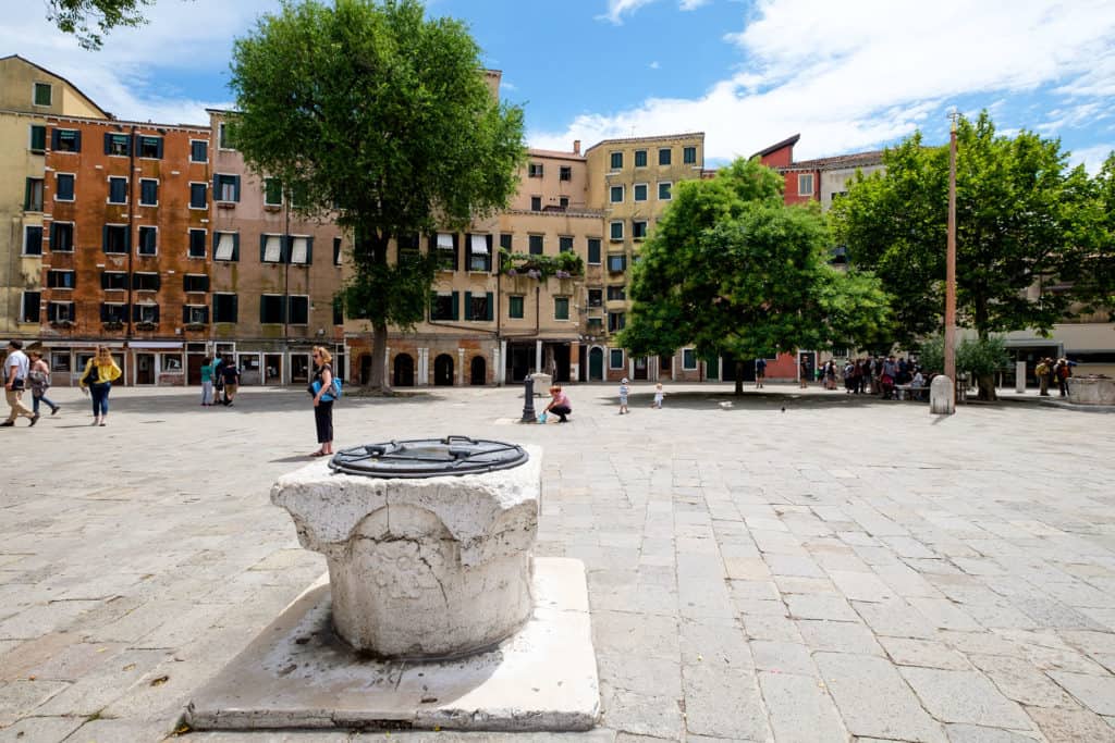 Campo del Ghetto with Venetian wells, fountain, gondolier and trees. Sestiere of Cannaregio Campo del Ghetto with Venetian wells, fountain, gondolier and trees. Sestiere of Cannaregio