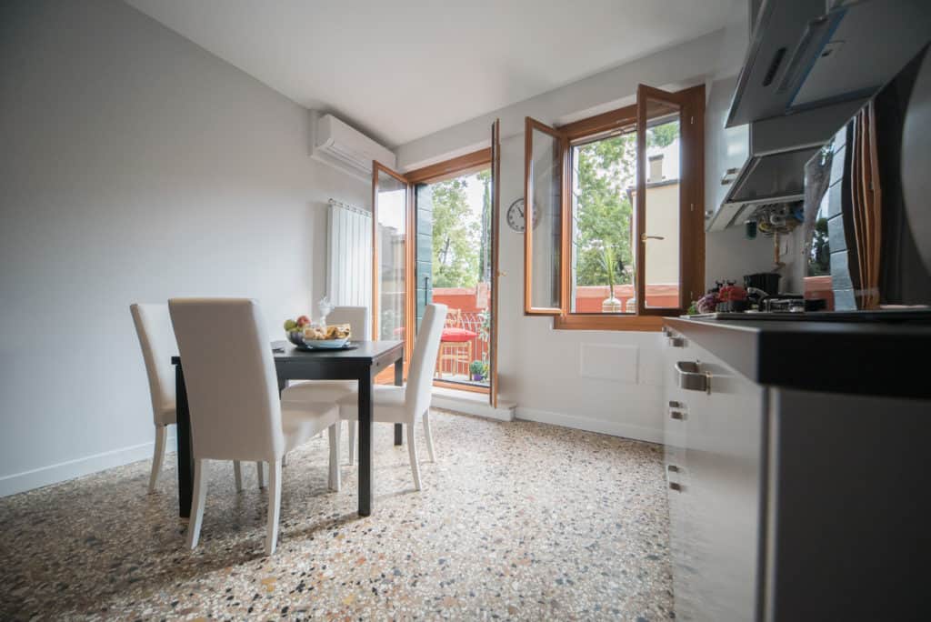 Left side of the big kitchen with modern furnishing and view on the terrace - Venier Apartment Left side of the big kitchen with modern furnishing and view on the terrace - Venier Apartment