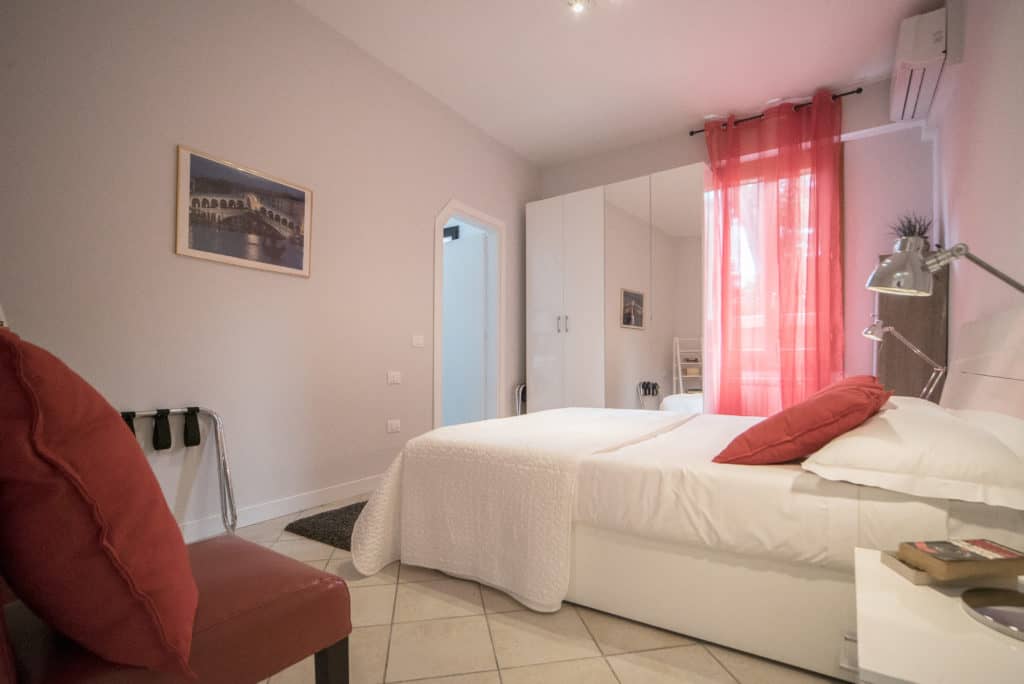 Left side of the modern double bedroom with red curtains - Venier Apartment Left side of the modern double bedroom with red curtains - Venier Apartment