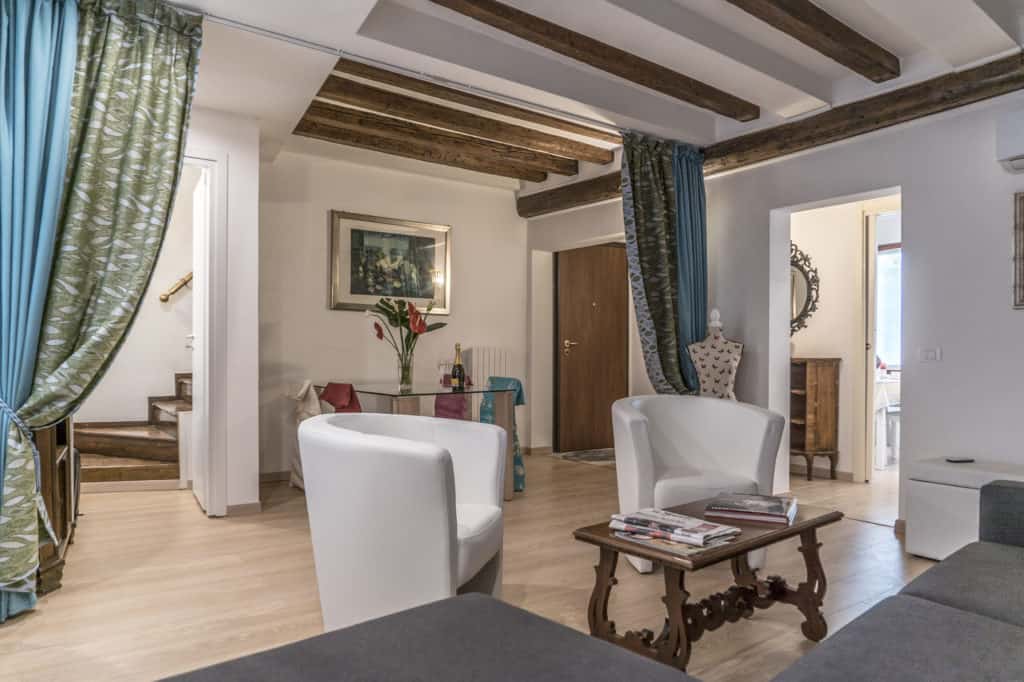 Living room with modern armchairs and exposed beams - Ca' Alba Apartment Living room with modern armchairs and exposed beams - Ca' Alba Apartment