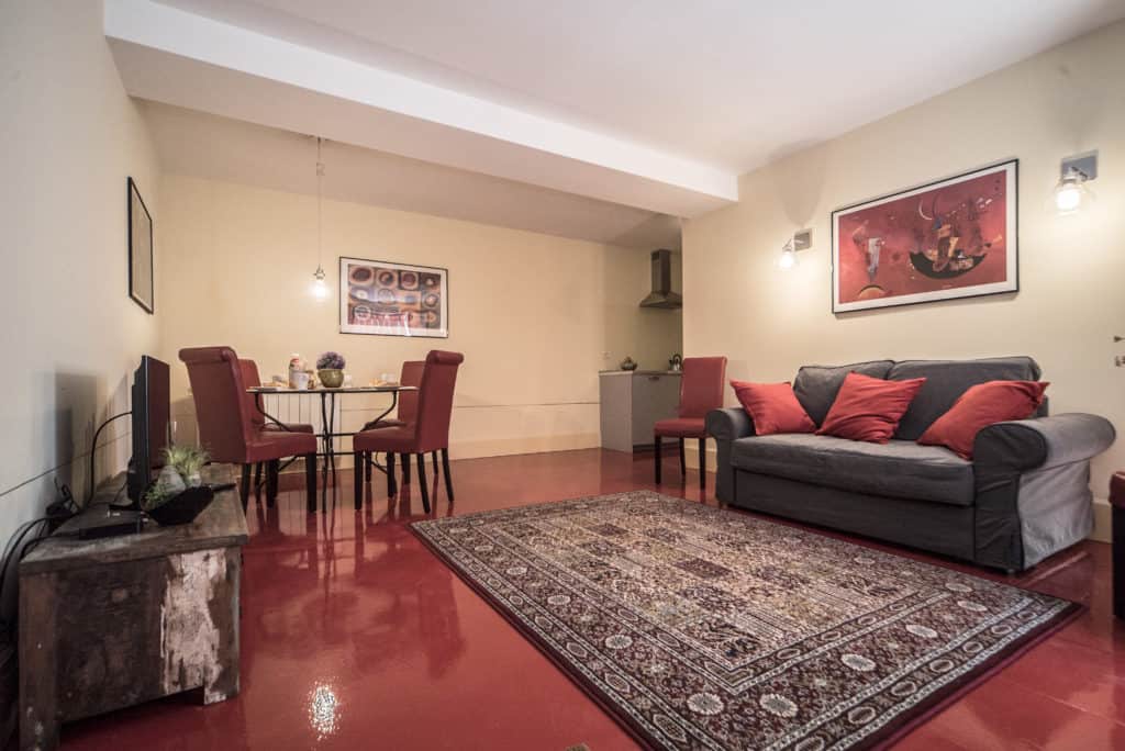 Entrance of the large living room with red floor and small dining table - Kandinskij House Apartment Entrance of the large living room with red floor and small dining table - Kandinskij House Apartment