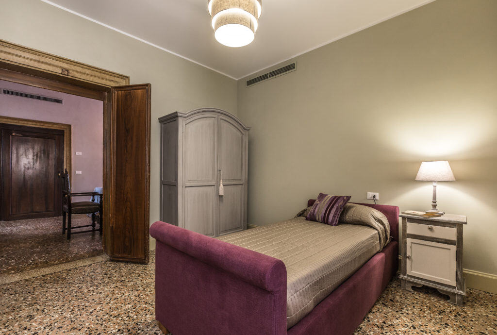Large single bedroom with purple bed - Palazzina Canal Apartment Large single bedroom with purple bed - Palazzina Canal Apartment