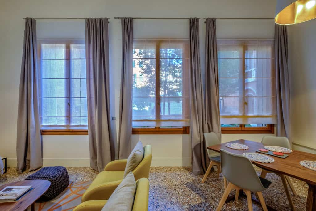 Right view of the large living room with modern furnishing and dining table - Palazzo Molin Guaranà Apartment Right view of the large living room with modern furnishing and dining table - Palazzo Molin Guaranà Apartment