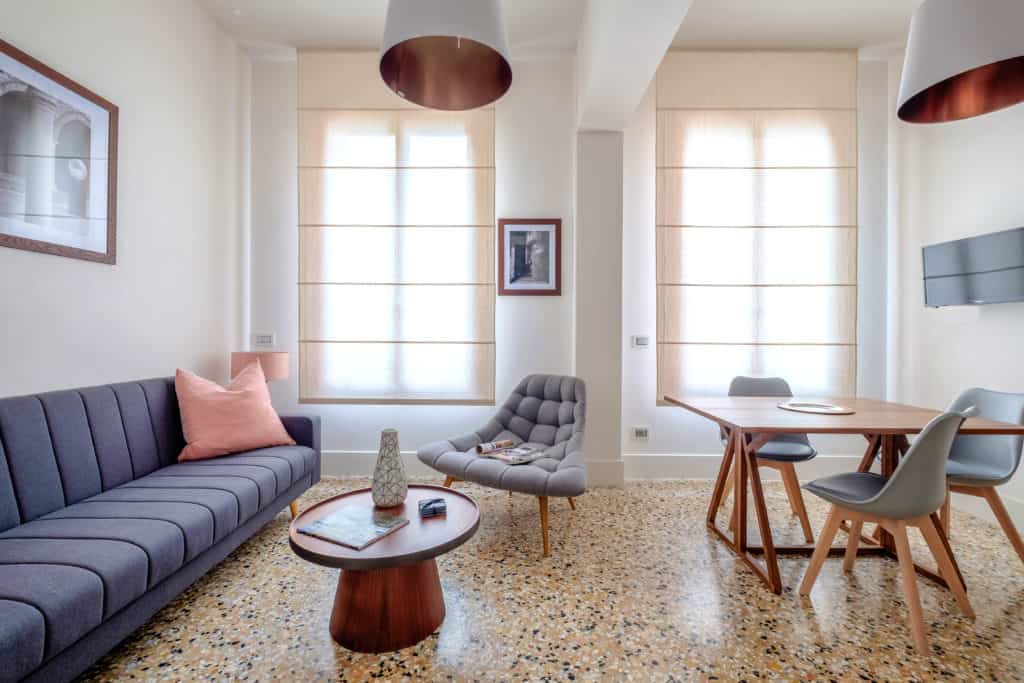 Luminous living room with large sofa and dining table - Palazzo Molin Tiziano Apartment Luminous living room with large sofa and dining table - Palazzo Molin Tiziano Apartment