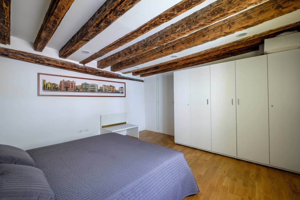 Entrance view of the large master bedroom with exposed beams and wardrobe - The Lion's 5 Apartment Entrance view of the large master bedroom with exposed beams and wardrobe - The Lion's 5 Apartment