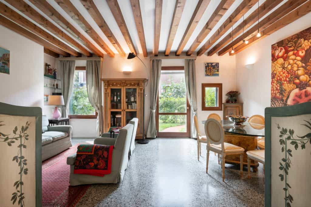 Luminous living room with vintage furnishing and exposed beams -