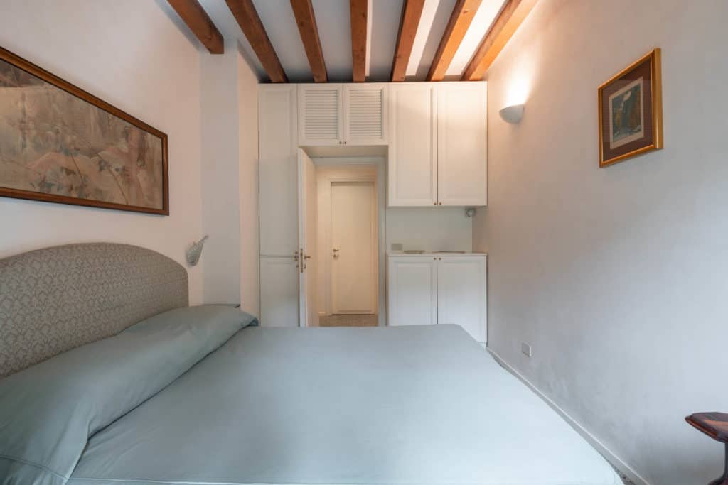 Right view of the luminous small master bedroom with vintage fur
