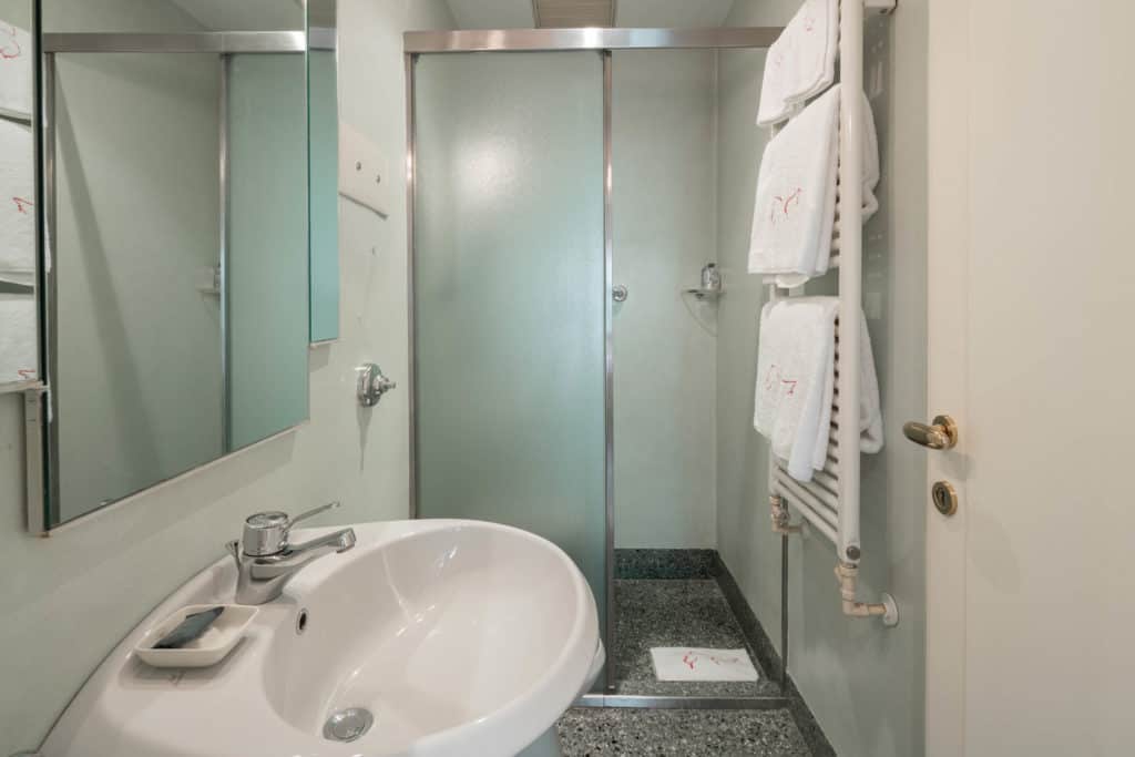 Right view of the small bathroom with marbled sink and tub - Gar