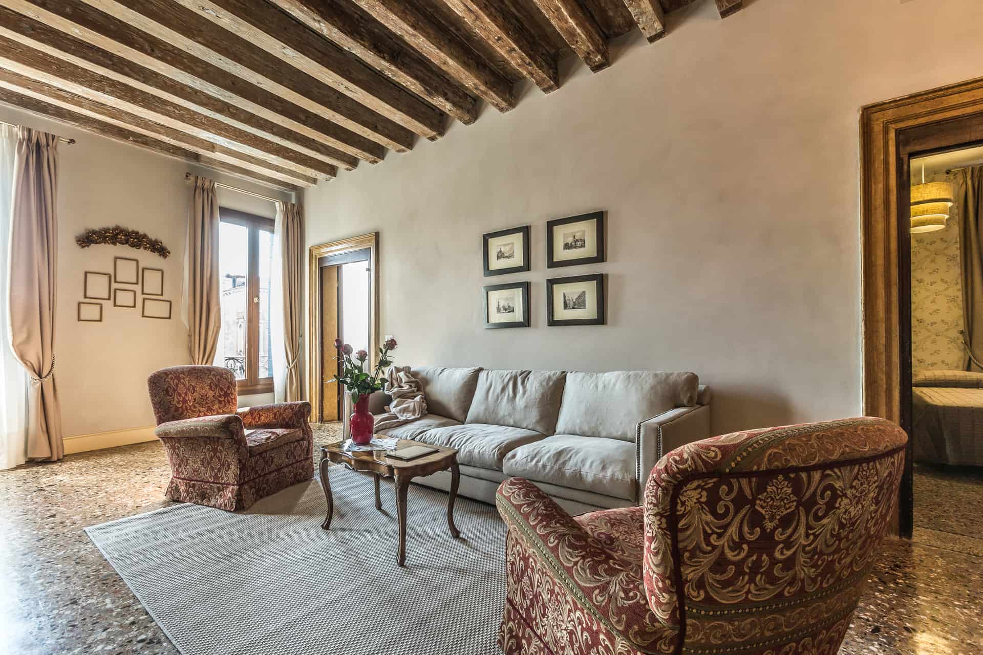 Left view of the luminous living room with vintage armchairs and large sofa - Palazzina Canal Apartment